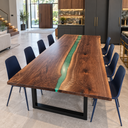 Corner view of a black walnut tabletop with rich brown grain and a narrow green epoxy resin channel