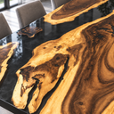 Close-up of figured walnut grain, golden wood edges and glossy black epoxy resin