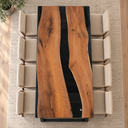Overhead view of black walnut grain framed by black epoxy resin on a dining tabletop