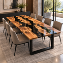 Angled view of an olive wood epoxy resin dining table beside tall windows, highlighting the black resin and golden grain.