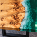 Close-up of patterned poplar wood meeting white wave details and glossy green epoxy resin at the tabletop edge